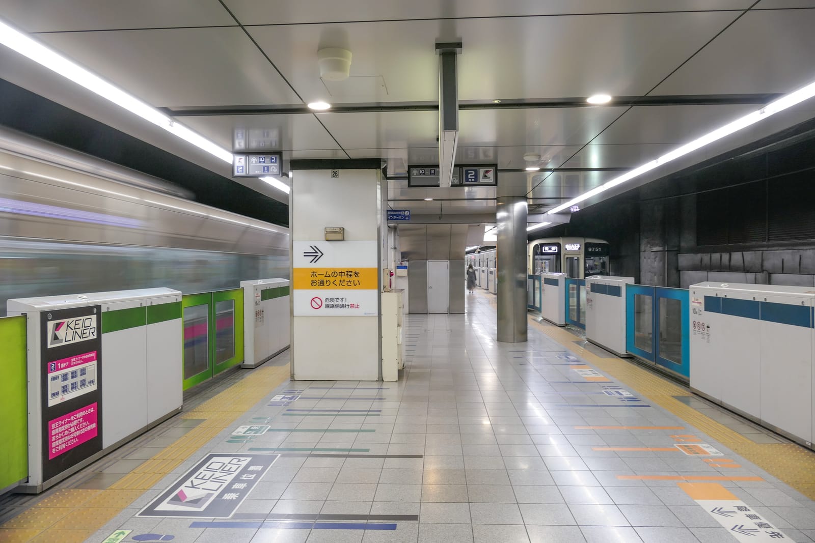 The underground Keio Line platform at Shinjuku Station, with platform doors and a train pulling in