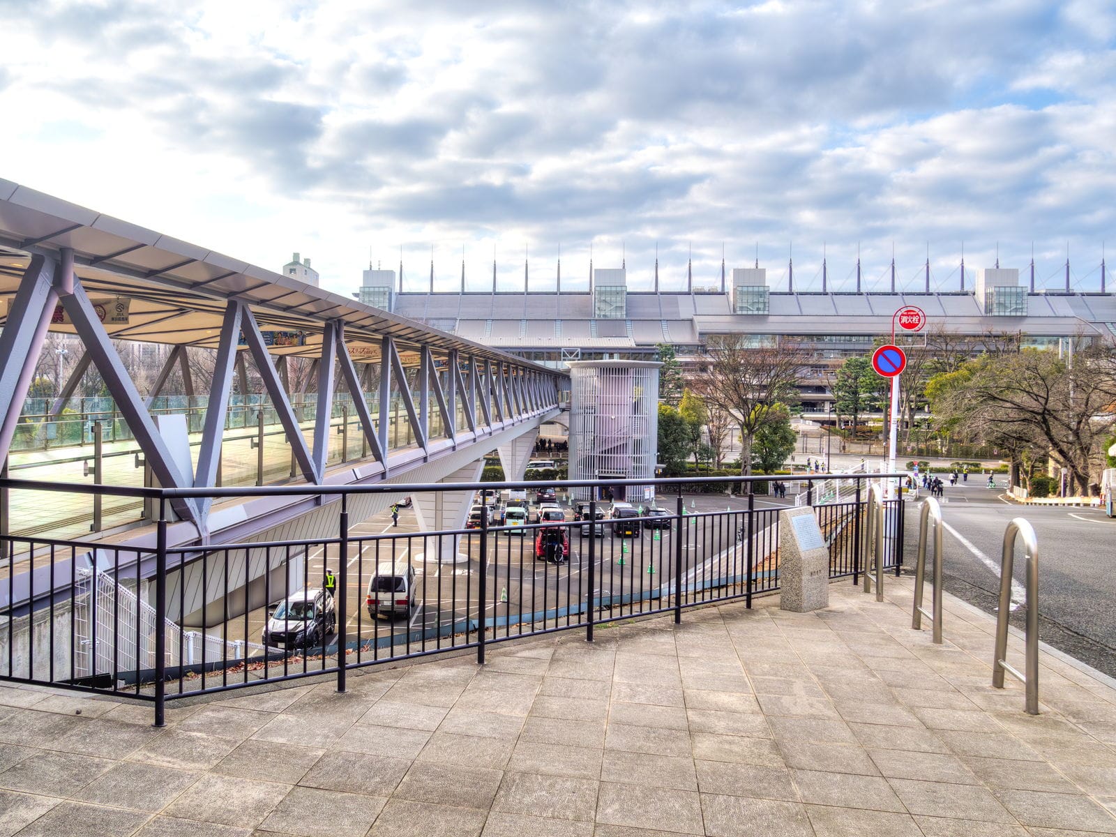 The covered pedestrian overpass leading toward Tokyo Racecourse, with the grandstand roof behind.