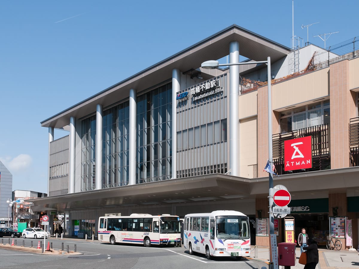 The Keio Line building of Takahatafudo Station with buses at the station square