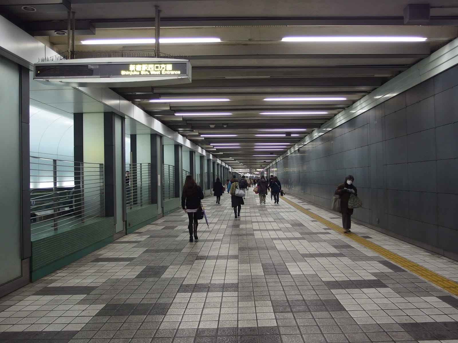 An underground passage in West Shinjuku signposted toward Shinjuku Station's West Exit