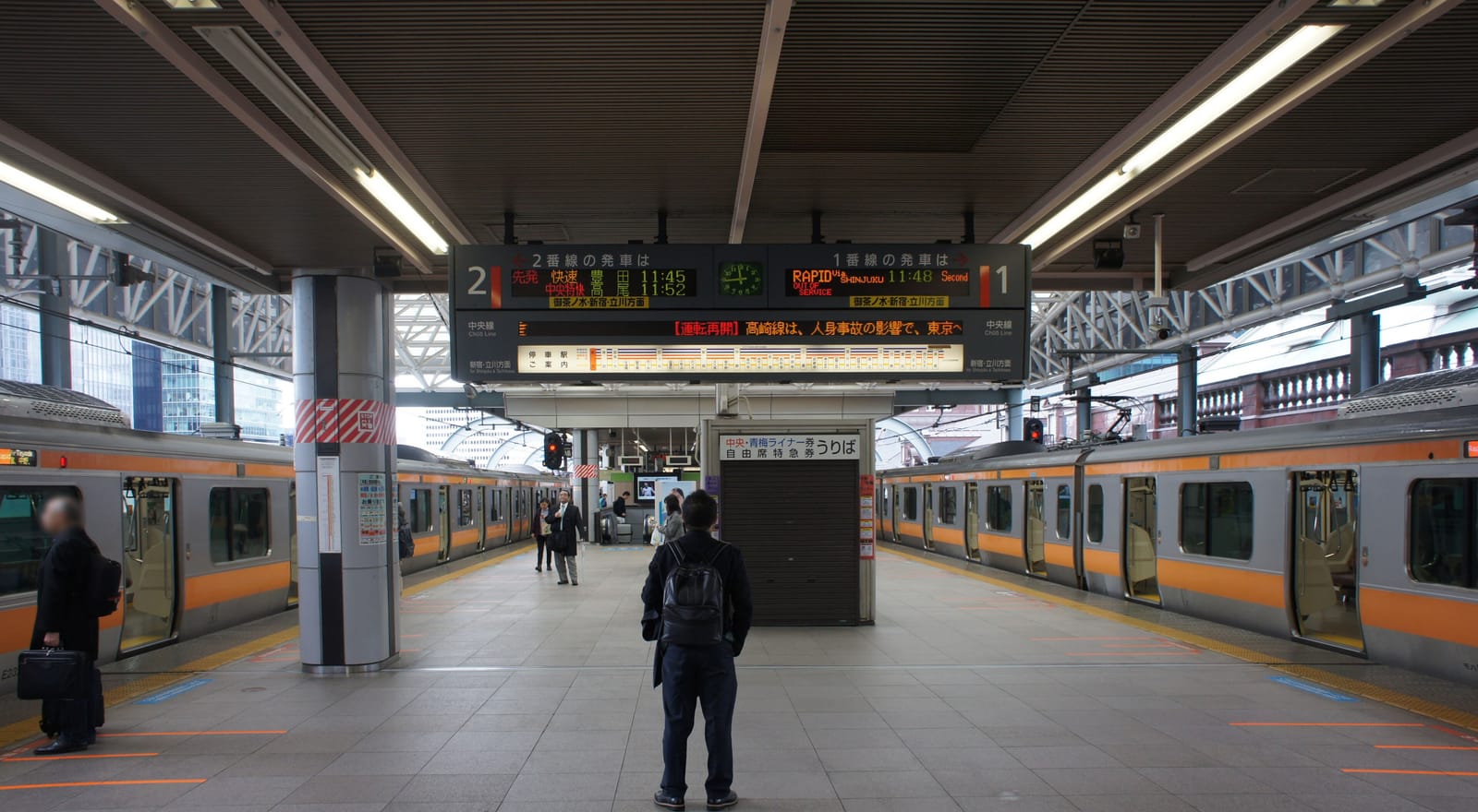 Platforms 1 and 2 of the JR Chuo Line at Tokyo Station, with orange-striped trains