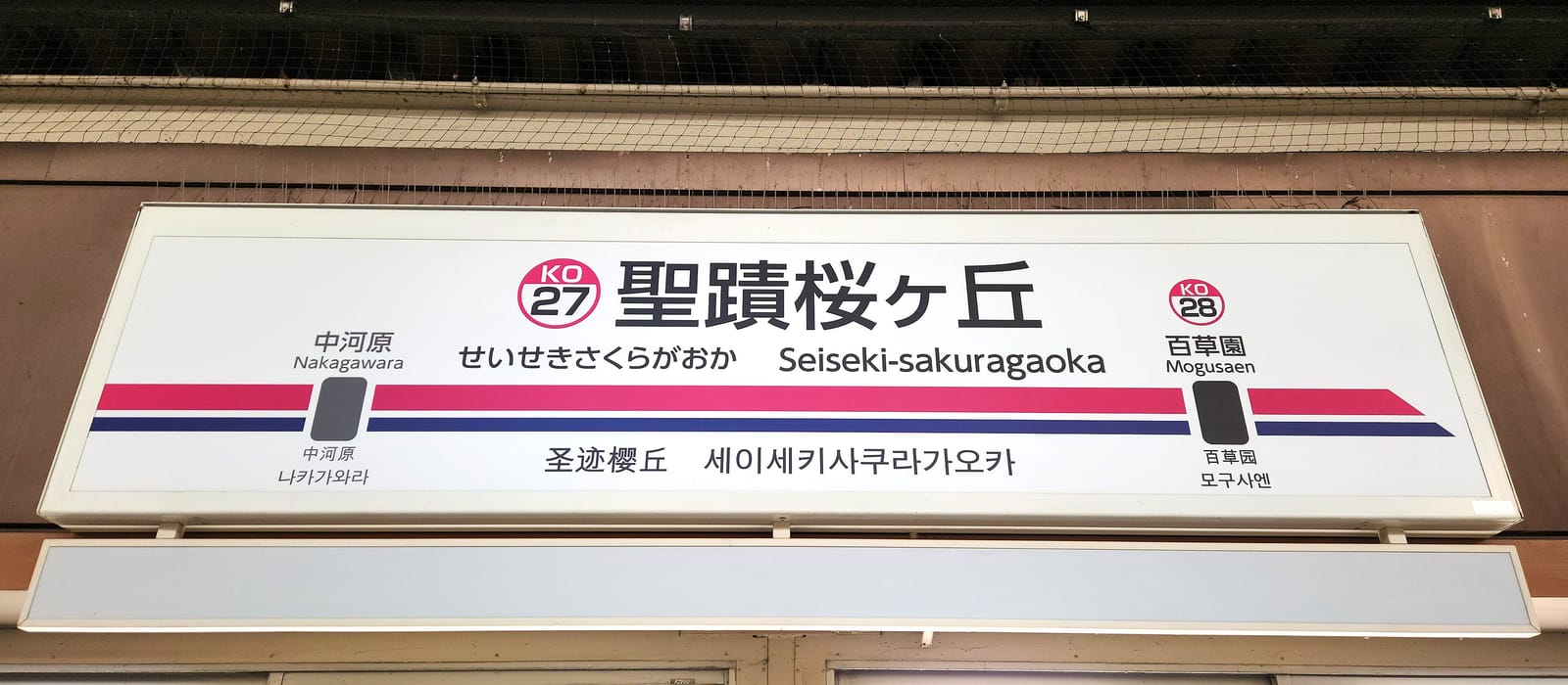 The Seiseki-sakuragaoka station name sign with station number KO27 on the Keio Line platform